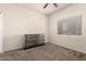 Neutral bedroom with new gray dresser, carpet, window and a ceiling fan at 5039 S 237Th Ln, Buckeye, AZ 85326