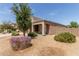 Single-story home with desert landscaping, a covered porch, and a mature shade tree at 5039 S 237Th Ln, Buckeye, AZ 85326