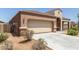 Single-story home featuring a two-car garage, desert landscaping, and a covered porch at 5039 S 237Th Ln, Buckeye, AZ 85326