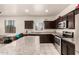 Modern kitchen features granite countertops, stainless steel appliances, ample cabinet space, and a bright window at 5039 S 237Th Ln, Buckeye, AZ 85326