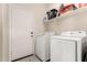 Bright laundry room with white washer and dryer and wire rack shelving at 5039 S 237Th Ln, Buckeye, AZ 85326