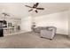 Spacious living room featuring modern ceiling fan, neutral paint and carpet, and an open floor plan at 5039 S 237Th Ln, Buckeye, AZ 85326
