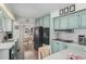 Kitchen featuring blue cabinets, modern black appliances, and open access to dining area at 506 S 81St Pl, Mesa, AZ 85208