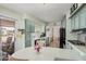 Bright kitchen featuring blue cabinetry, black appliances, and adjacent dining area at 506 S 81St Pl, Mesa, AZ 85208
