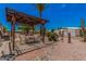 Outdoor patio area with a pergola, dining table, and desert landscaping at 506 S 81St Pl, Mesa, AZ 85208