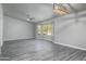 Open living room with gray flooring, large windows, and a modern ceiling fan at 540 Leisure World --, Mesa, AZ 85206