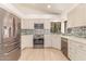 Contemporary kitchen with updated stainless appliances, light-colored cabinets, and tile backsplash at 6325 E Helm Dr, Scottsdale, AZ 85254