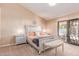 This main bedroom features an upholstered bed, slider to the patio, and neutral decor at 6325 E Helm Dr, Scottsdale, AZ 85254