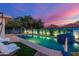 Enjoy the beautiful pool and backyard area with its lounge chairs and basketball hoop at dusk at 6325 E Helm Dr, Scottsdale, AZ 85254