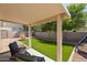 Well-maintained backyard with an artificial lawn, mature trees, and covered patio at 6425 S Kimberlee Way, Chandler, AZ 85249