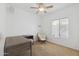 Well-lit bedroom featuring a ceiling fan, a plush chair, and a modern desk workspace at 6425 S Kimberlee Way, Chandler, AZ 85249