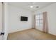 Bright bedroom featuring carpeted floors, neutral walls, and a mounted TV at 6425 S Kimberlee Way, Chandler, AZ 85249