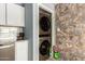 Functional laundry area featuring a stacked washer and dryer, cabinets, and patterned wall tiles at 6541 N 41St Ave, Phoenix, AZ 85019