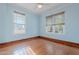 Bright bedroom features hardwood floors, two windows, and a ceiling fan at 711 E Mckinley St, Phoenix, AZ 85006