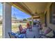 Back patio with cushioned seating, ceiling fan, lighting, and view of the spacious backyard and neighboring homes at 742 W Agrarian Hills Dr, San Tan Valley, AZ 85143