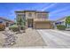 Home exterior features a two-car garage, neutral paint, stone accents, gravel landscaping, and a paved driveway at 742 W Agrarian Hills Dr, San Tan Valley, AZ 85143
