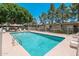 Full view of a community pool with lounge chairs, a table, and a large umbrella at 7740 E Heatherbrae Ave # 3, Scottsdale, AZ 85251