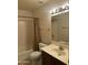 Bathroom with tile floor, a toilet, vanity, mirror and shower-tub with brown curtain at 8155 W Desert Cove Ave, Peoria, AZ 85345
