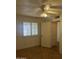 View of the bedroom with a ceiling fan, and window with white shutter blinds, next to doorway to another room at 8155 W Desert Cove Ave, Peoria, AZ 85345