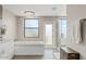 Bright bathroom with tub, elegant chandelier, and seamless glass shower at 8361 E San Rafael Dr, Scottsdale, AZ 85258