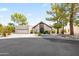 View of the home's front exterior featuring desert landscaping, mature trees, and a three-car garage at 8361 E San Rafael Dr, Scottsdale, AZ 85258