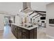 Open concept with spacious island, range hood, dark cabinets, and access to the living room at 8361 E San Rafael Dr, Scottsdale, AZ 85258