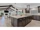 Kitchen and living room area with an island, range hood, dark wood cabinets, and vaulted ceiling at 8361 E San Rafael Dr, Scottsdale, AZ 85258