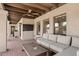 Inviting covered patio with a comfortable seating area, exposed wood beams, and a ceiling fan at 8361 E San Rafael Dr, Scottsdale, AZ 85258