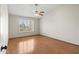 Spacious bedroom with wood floors, large window, and modern ceiling fan at 8431 W Utopia Rd, Peoria, AZ 85382