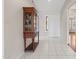 Bright entryway featuring white tile flooring and a classic wooden display cabinet at 8431 W Utopia Rd, Peoria, AZ 85382
