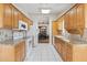 Efficient kitchen boasts white appliances, tiled floor and eat in dining through arched entryway at 8431 W Utopia Rd, Peoria, AZ 85382