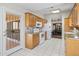 Efficient kitchen boasts white appliances, tiled floor and eat in dining through arched entryway at 8431 W Utopia Rd, Peoria, AZ 85382