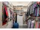 Organized walk-in closet with custom shelving, hanging rods, and a convenient blue stool at 10222 E Southwind Ln # 1018, Scottsdale, AZ 85262