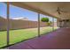 Covered patio with ceiling fan overlooks the grassy backyard with block fence and mature trees at 10845 W Manzanita Dr, Peoria, AZ 85345