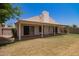Large, well-maintained backyard showing the covered patio, grassy area, and house with chimney at 10845 W Manzanita Dr, Peoria, AZ 85345