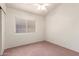 Simple bedroom design showing neutral carpet, a ceiling fan, and a window with blinds at 10845 W Manzanita Dr, Peoria, AZ 85345