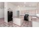 Bright kitchen featuring tile flooring, an island, and black appliances at 10845 W Manzanita Dr, Peoria, AZ 85345
