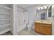 Bathroom with a tub, toilet, storage shelves, wood vanity, and sink at 1090 S Bogle Ct, Chandler, AZ 85286