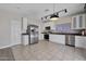 Bright kitchen features stainless steel appliances, white cabinetry, tile floors, and modern lighting at 1090 S Bogle Ct, Chandler, AZ 85286