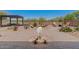 Well-manicured backyard with rock sculpture, desert landscaping, seating and dining areas at 10914 E Tarragon Ave, Mesa, AZ 85212