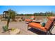 Backyard with lounging chairs, desert landscaping, and a fire pit perfect for outdoor gatherings and enjoying the desert scenery at 10914 E Tarragon Ave, Mesa, AZ 85212