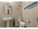 Bright half-bath with unique seashell mirror, pedestal sink, toilet, and charming whale decor at 10914 E Tarragon Ave, Mesa, AZ 85212