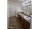 Bright bathroom featuring a tiled countertop, decorative lighting, and a spacious mirror at 13004 W Saint Moritz Ln, El Mirage, AZ 85335