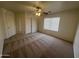 Spacious bedroom with large closet, fan and window with blinds and carpeted floor at 13004 W Saint Moritz Ln, El Mirage, AZ 85335