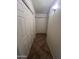 Hallway with tiled floors and multiple white doors with closet space at 13004 W Saint Moritz Ln, El Mirage, AZ 85335
