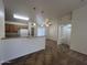 Open-concept kitchen with tile flooring, breakfast bar, and a bright view to the dining area at 13004 W Saint Moritz Ln, El Mirage, AZ 85335