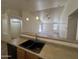 Kitchen breakfast bar and sink area looking out to the living room with ceiling fan at 13004 W Saint Moritz Ln, El Mirage, AZ 85335
