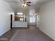 Bright living room with ceiling fan, carpeted area, and partial view of the open kitchen at 13004 W Saint Moritz Ln, El Mirage, AZ 85335