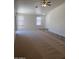 Bright open living room featuring carpet, tile entryway, and natural light from multiple windows at 13004 W Saint Moritz Ln, El Mirage, AZ 85335