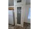 Close up of the pantry door, with decorative glass, next to a white refrigerator at 13004 W Saint Moritz Ln, El Mirage, AZ 85335